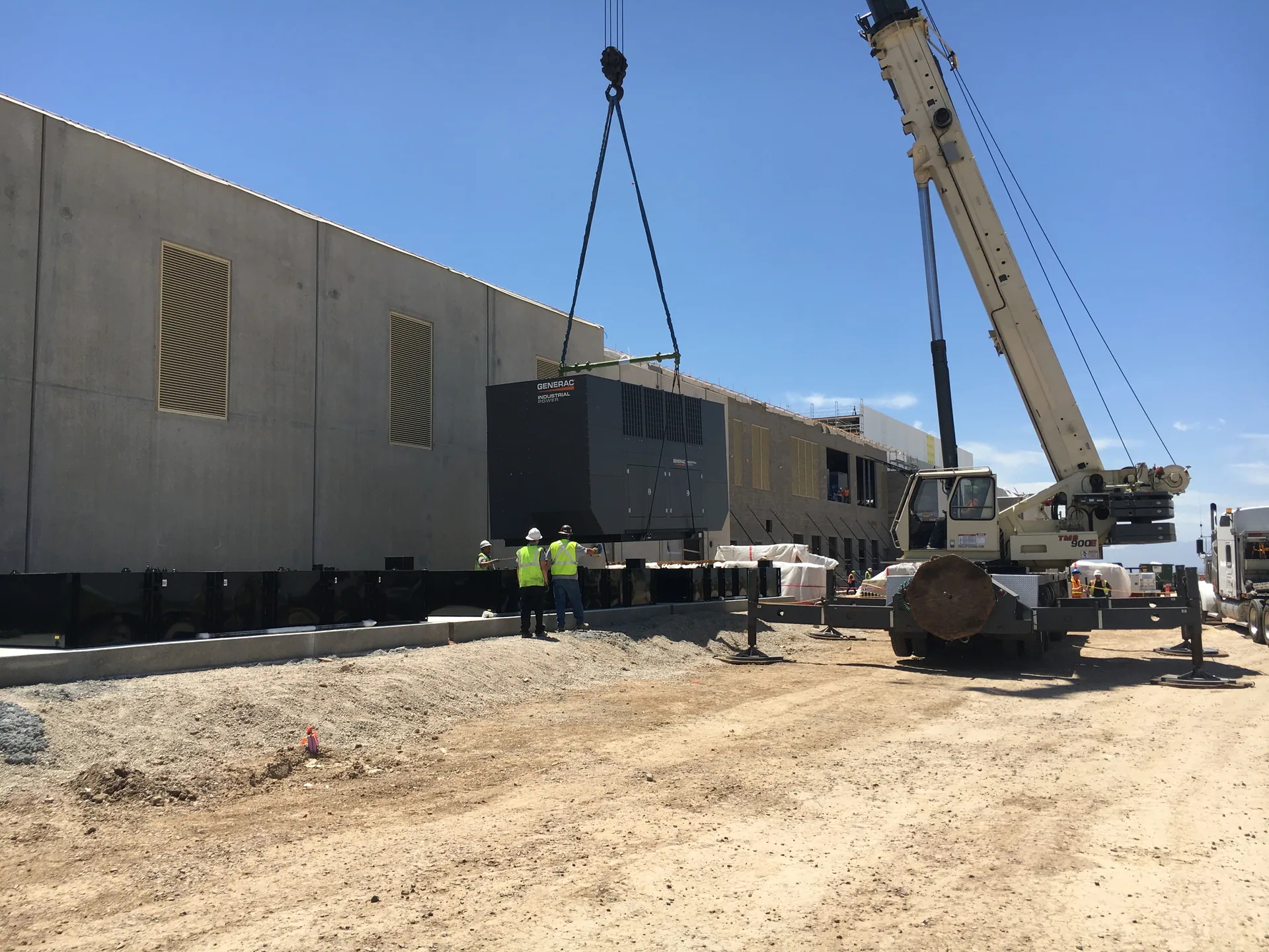 Crane setting a large industrial generator at a Visions project