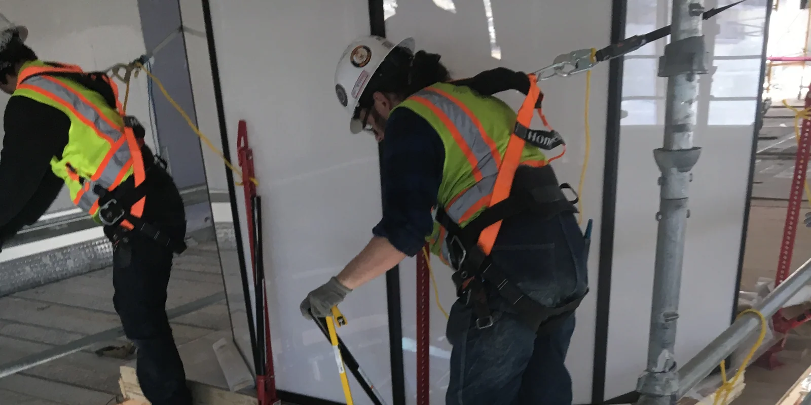 Construction team safely positioning large equipment at elevation