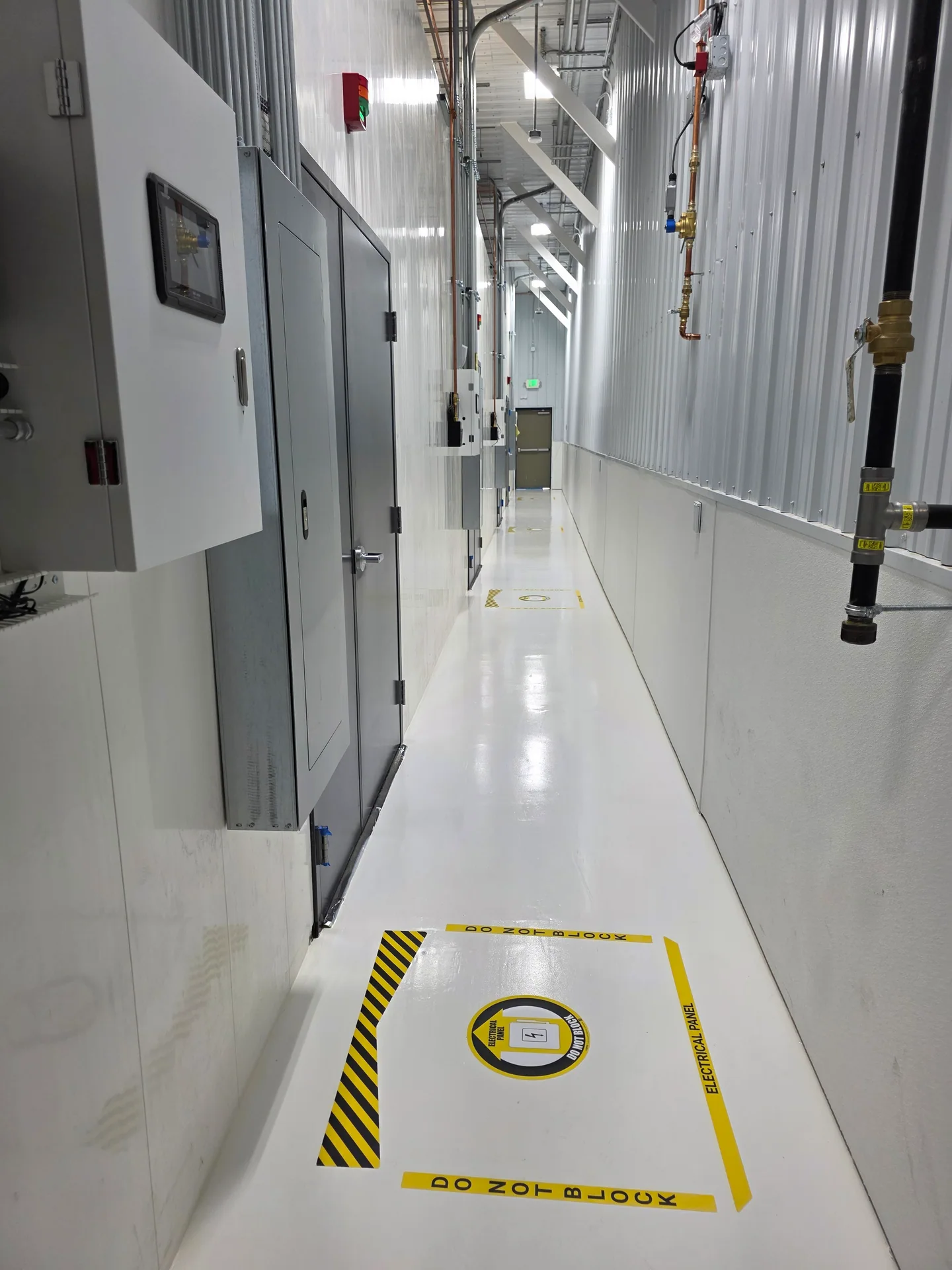 Completed light-colored resinous floor in a technical facility corridor